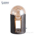 La base cilíndrica de metal es compatible con la lámpara de escritorio de la bola de vidrio